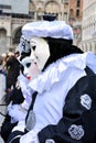An unidentified couple of man and woman wear Pierrot fancy dresses with black and white beret during Venice Carnival